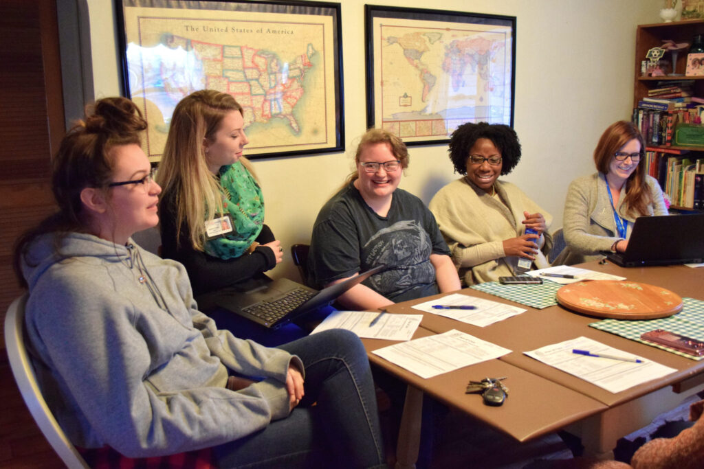 Adult & Child wraparound staff sitting at a table having a discussion